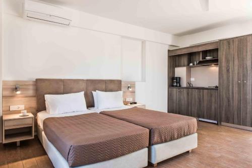 a bedroom with a large bed and a kitchen at Gerona Mare Apartments in Gerani Chanion