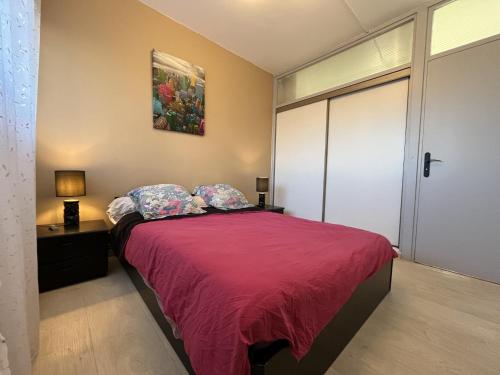 une chambre avec un lit avec une couette rouge dans l'établissement le mediterranee vasapolli, à Fréjus