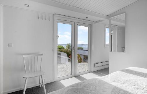 a bedroom with a white bed and a chair at Lovely Home In Ølsted With Kitchen in Ølsted