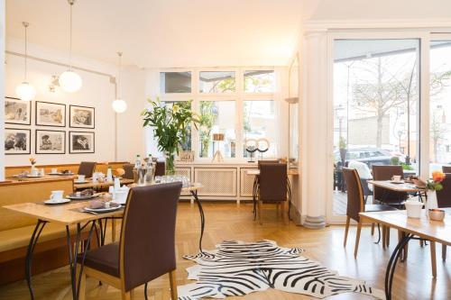 アンダーナッハにあるHotel Am Helmwartsturmのシマウマの敷物を敷いたテーブルと椅子が備わるレストラン