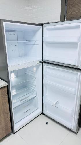 a refrigerator with its door open in a kitchen at Spacious & Stylish 3-Bedroom Home in a Prime Location in Dubai