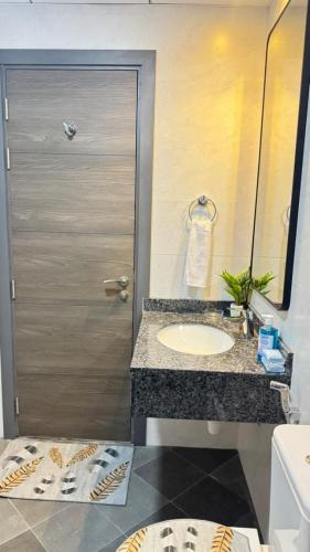 a bathroom with a sink and a door with a mirror at Spacious & Stylish 3-Bedroom Home in a Prime Location in Dubai
