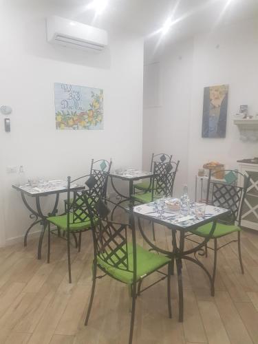 a group of tables with green chairs in a room at B&B DieMme Amalfi Coast in Vietri sul Mare