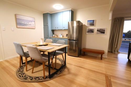 una cucina con tavolo e frigorifero in acciaio inox di Cozy Family Home 10min to Airport and Pet friendly ad Auckland