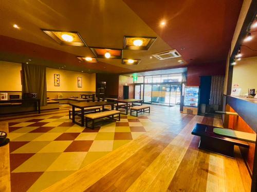 a lobby with tables and benches on a checkered floor at Kashiwaya in Chikuma