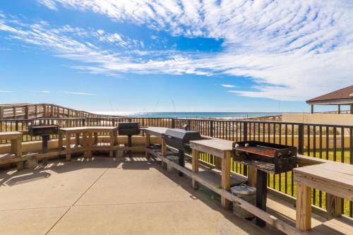 eine Terrasse am Strand mit Picknicktischen und Bänken in der Unterkunft Phoenix II Vacation Condos in Orange Beach