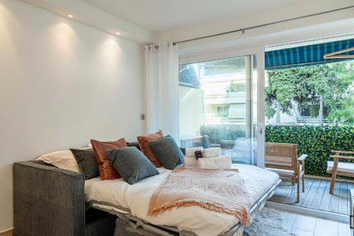 un lit dans une chambre avec une grande fenêtre dans l'établissement Renovated apt with Parking & Terrace - Palm Beach, à Cannes