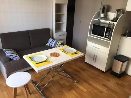 un petit salon avec une table et un canapé dans l'établissement Cozy studio with balcony and secure parking, à Pau