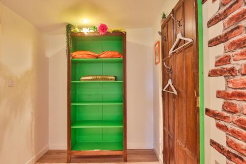 une étagère verte dans un couloir avec du pain dans l'établissement CHALET CAMPAGNE - Climatisé - Les Belles Ouvrières, à Clermont-Créans