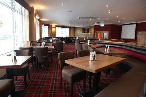 a restaurant with tables and chairs and a pool table at Leapark Hotel in Grangemouth