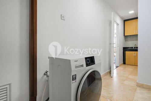 a washing machine in a room with a kitchen at Camila by Kozystay - Kuningan in Jakarta