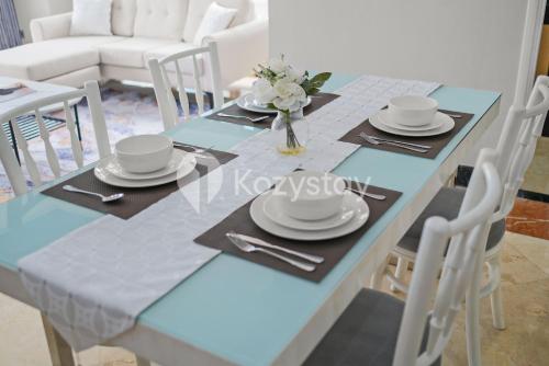 a blue dining table with plates and napkins on it at Camila by Kozystay - Kuningan in Jakarta