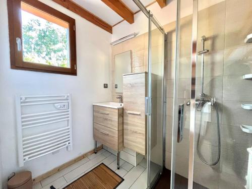 La salle de bains est pourvue d'une douche et d'une cabine de douche en verre. dans l'établissement Maisonnette climatisée proche de la Dune, à La Teste-de-Buch