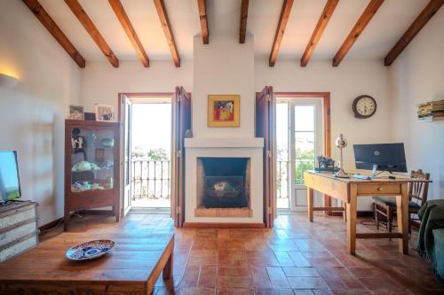 a living room with a desk and a fireplace at Casa da Alba in Alentejo in Melides