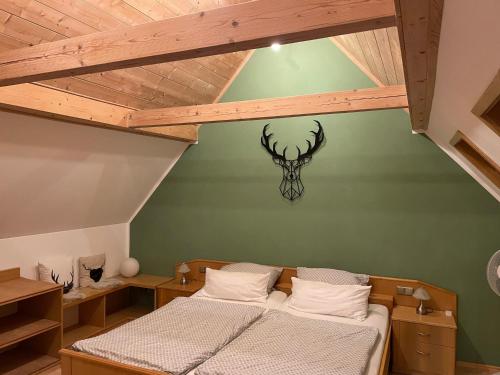 a bedroom with a bed with a antelope head on the wall at Ferienwohnungen Eisenhofer in Kelheim