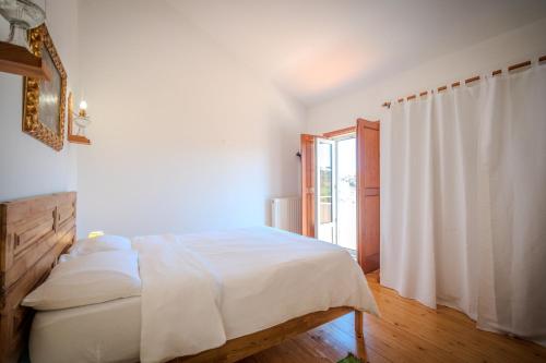 a white bedroom with a bed and a window at Casa da Alba in Alentejo in Melides