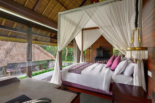 a bedroom with a bed with a canopy at Kayumanis Ubud Private Villas & Spa in Ubud