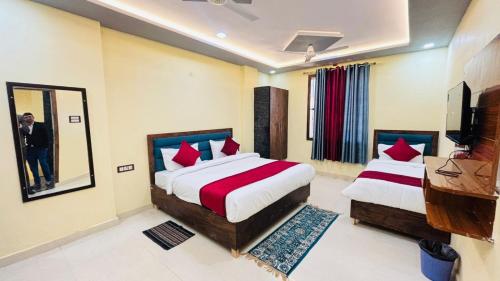 a hotel room with two beds and a mirror at Hotel AL Taj , Agra in Agra