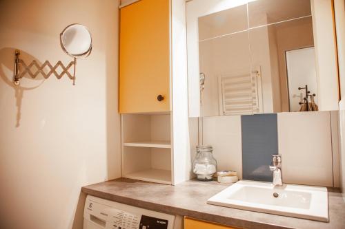 une salle de bain avec un lavabo et un miroir dans l'établissement Rez de chaussée, place du marché, plage à pied, à Pornichet