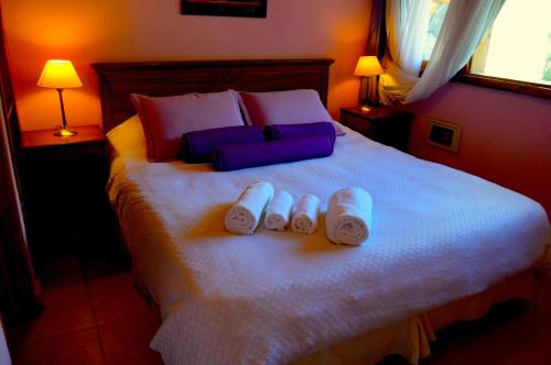 1 dormitorio con 1 cama con 2 toallas y 2 lámparas en Posadas Aurelio en San Carlos de Bariloche