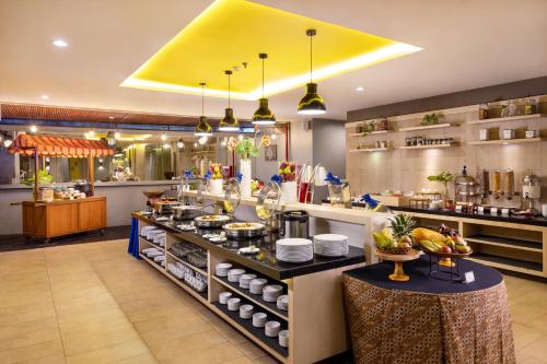a restaurant with a buffet line with food at Sevn Legian in Legian