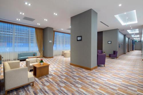 a lobby with couches and chairs in a building at Hampton By Hilton Kocaeli Symbol in Kocaeli
