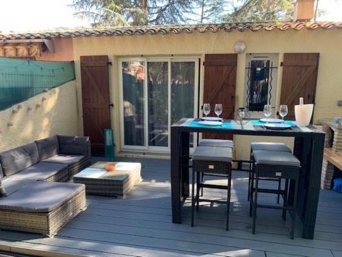 un patio avec une table, des chaises et un canapé dans l'établissement Maisonette Cap d 'Agde, au Cap d'Agde