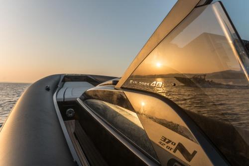 a boat in the water with the sun setting at Virtu on the Hill in Stelida