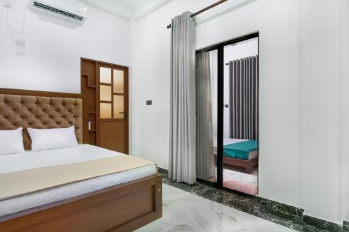 a bedroom with a bed and a sliding glass door at Amith Villa in Aluthgama