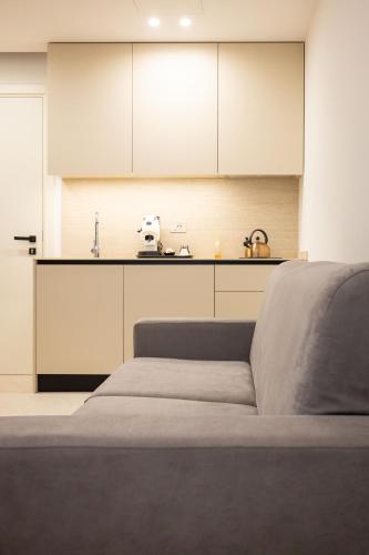 a kitchen with white cabinets and a bed in a room at Nora's Suites in Palermo