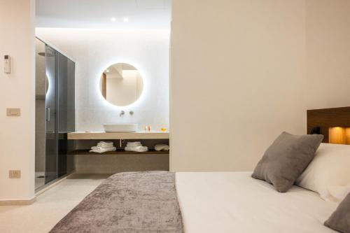 a bedroom with a bed with a sink and a mirror at Nora's Suites in Palermo