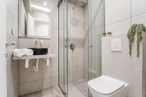 a bathroom with a shower with a toilet and a sink at Luna Luxury Suite - close to Acropolis in Athens