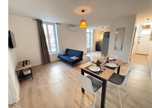 un salon avec une table et un canapé bleu dans l'établissement L'écrin de Roanne, 1st floor 4 pers Neptune 2, à Roanne