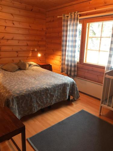 Un dormitorio con una cama en una cabaña de troncos en Pyrypolku 6, en Ruka