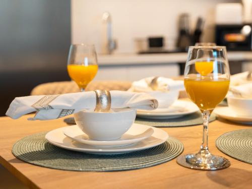 a table with two glasses of orange juice and a cup at Royal Vista at Downtown Views II - Downtown Dubai City Views - Brand New Luxury 2BR Apartment in Dubai