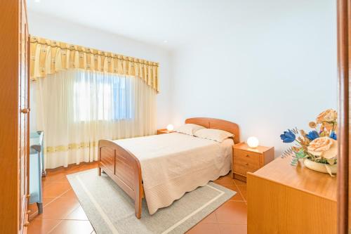 a bedroom with a bed and a dresser and a window at Beautiful Deluxe Villa 4 Bedroom in Aldeia de Brescos