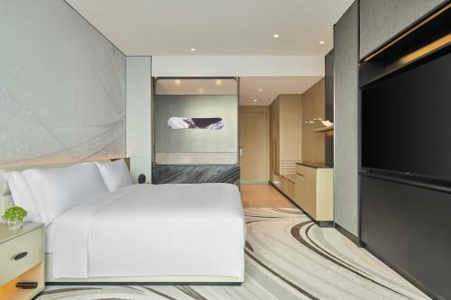 a hotel room with a bed and a flat screen tv at Crowne Plaza Shanghai Snow World by IHG in Shanghai
