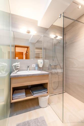 a bathroom with a sink and a shower at Reisslerhof Hotel & Apartments - by myNests in Gröbming