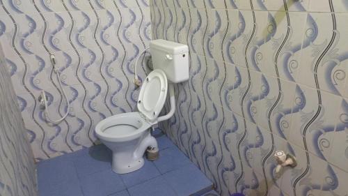 a bathroom with a white toilet in a room at Hotel Grand Arputha in Velankanni