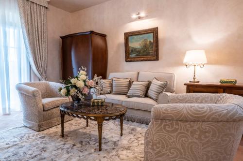 a living room with a couch and a table at Villa Petriolo - Small Luxury Hotels of the World in Cerreto Guidi