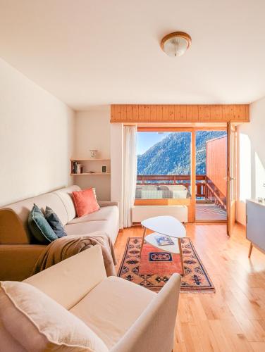 a living room with two couches and a large window at Ovronnaz vue imprenable, terrasse & accès bains in Ovronnaz