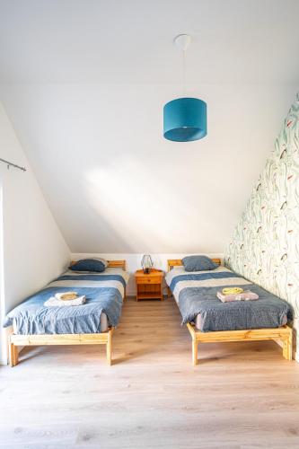 - une chambre avec 2 lits et une lumière bleue dans l'établissement Gite du Clos Masure - 4 pers - 10 min Etretat, à Gonneville-la-Mallet