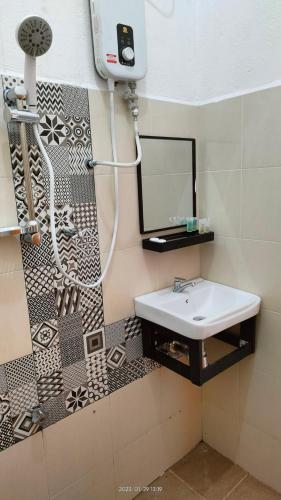 a bathroom with a sink and a mirror at Laman Hanaz in Pantai Cenang