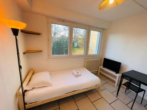 une petite chambre avec un lit et une télévision dans l'établissement Alyo, Studio proche centre 1p, à Caen
