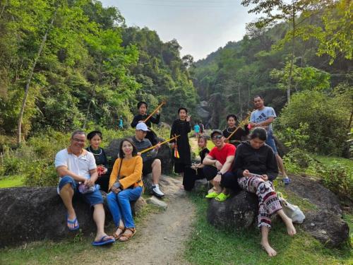 ハザンにあるNhà Lá Homestayの登山道の岩に座る人々