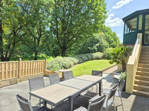 a wooden table and chairs on a patio at Maison Le Baron 13pers Tiffauges proche Puy du Fou in Tiffauges