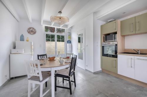 une cuisine et une salle à manger avec une table et des chaises dans l'établissement Maison cosy pour 4, à seulement 450m des plages !, à Pornichet