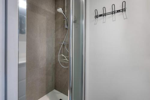 une douche dans une salle de bain avec une porte vitrée dans l'établissement Maison cosy pour 4, à seulement 450m des plages !, à Pornichet