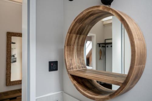 a wooden mirror on a wall next to a door at 4Hafenzeiten - NIE11 Hamburg in Niendorf