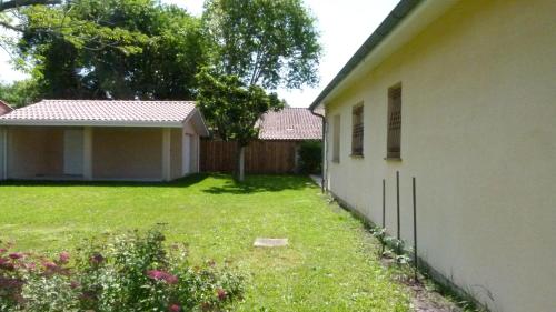 une maison avec une cour à côté d'une clôture dans l'établissement Les Calicots Sanguinet, à Sanguinet